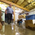 plumber wading through flooded basement